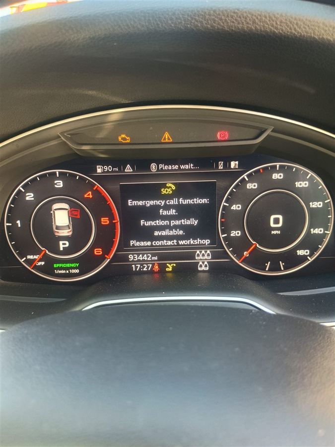 Audi instrument cluster showing an engine management light and a stored emergency call fault