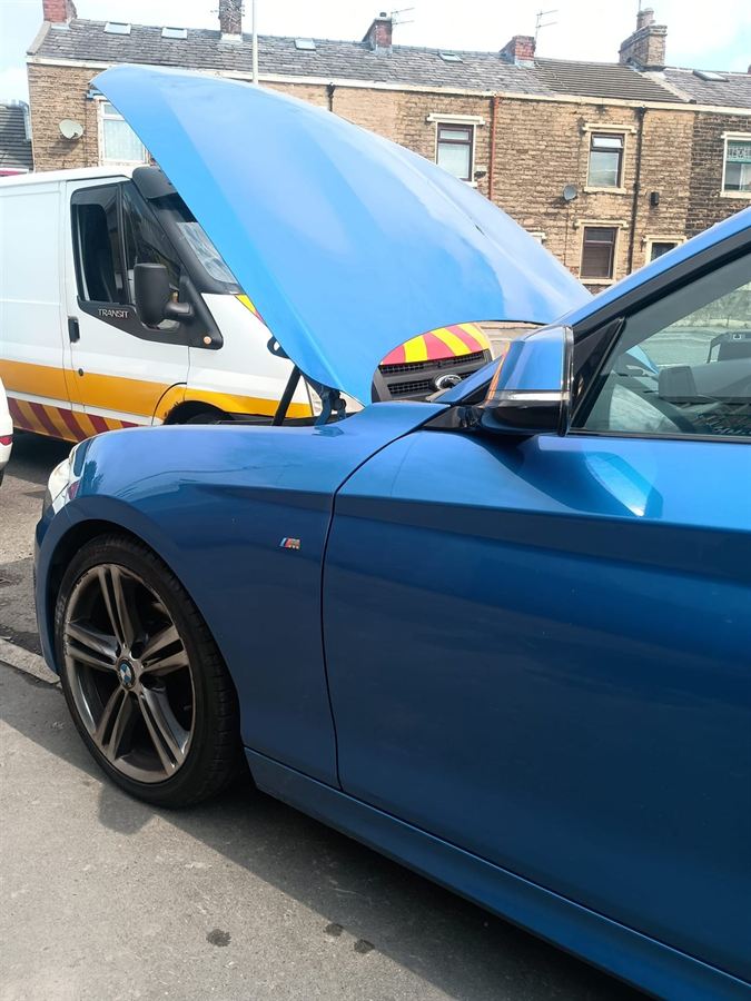 The HM Mobile van parked behind a blue BMW 2 Series with its bonnet up on a Lancashire street