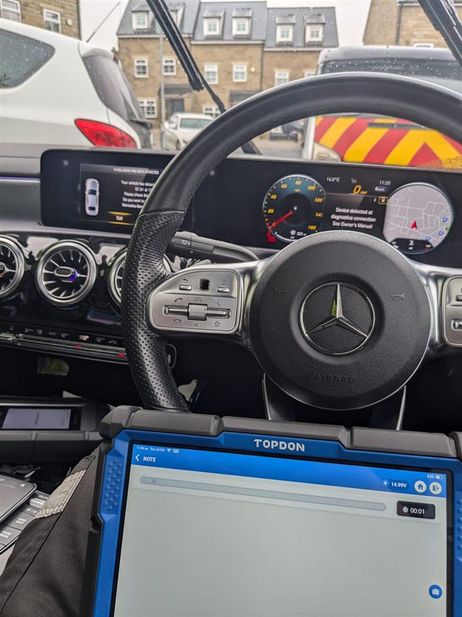 Mercedes A Class dashboard showing a collision detected warning with a Topdon diagnostic tablet in use