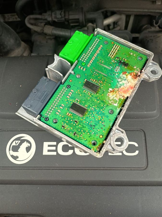 Vauxhall engine control unit opened up showing green and orange corrosion across the circuit board